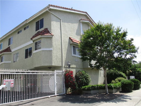 Front view of a multi-story residential building with gated entrance.