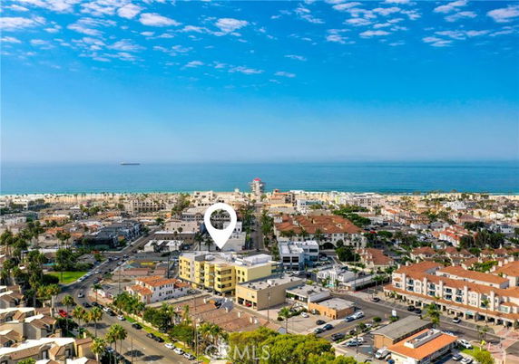 Panoramic view of a coastal city with buildings and the ocean in the distance.