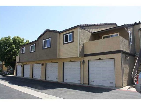 Front view of a two-story building with multiple garages on the ground floor.