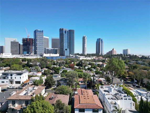 Panoramic view of urban skyline with tall buildings and residential area in the foreground.