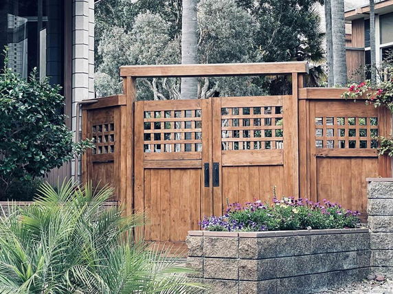 Front view of a wooden gate with decorative lattice design, part of a building's entry.