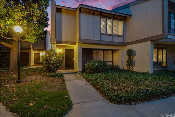 Front view of a two-story house with a pathway leading to the entrance.