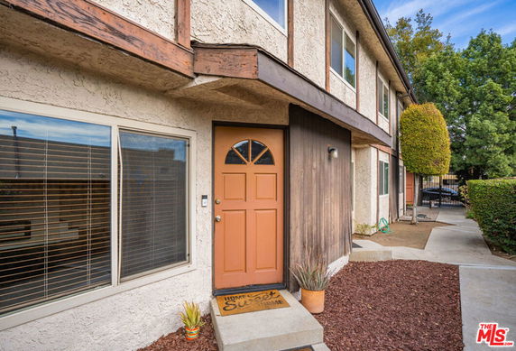 Front view of a two-story house with an orange door.