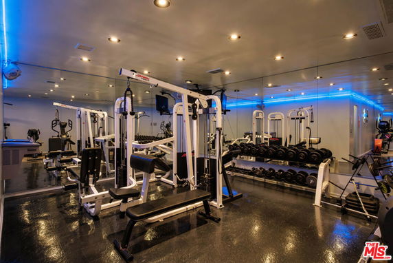 Interior view of a gym with various exercise equipment and mirrors.