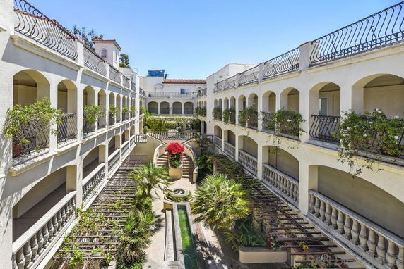 Courtyard view of a multi-story building with balconies and greenery.