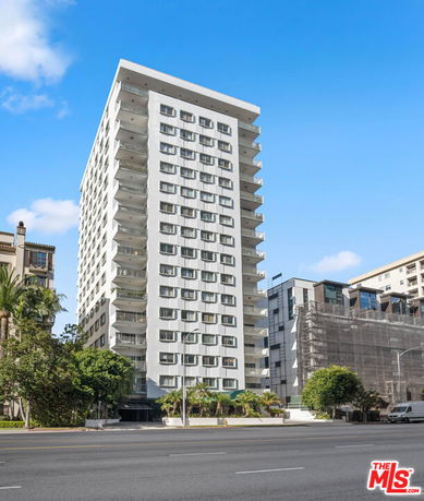 Front view of a multi-story apartment building with balconies.