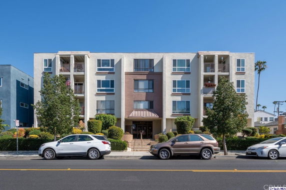 Front view of a four-story apartment building with balconies.