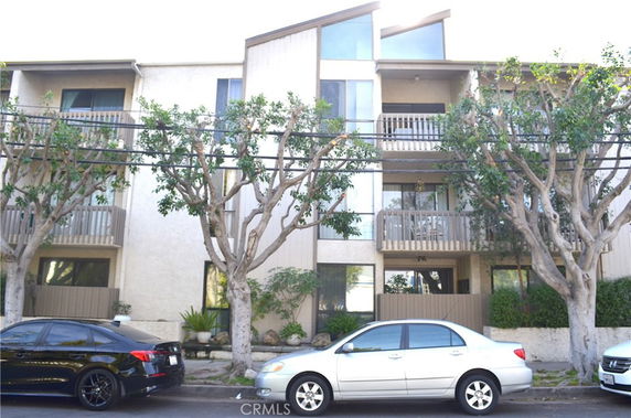 Front view of a multi-story apartment building with balconies.