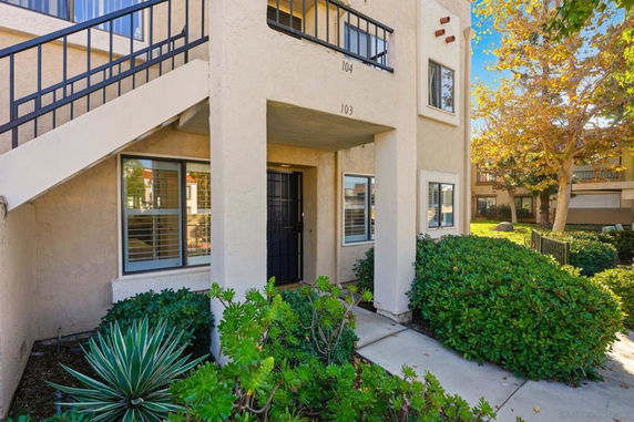 Front view of a multi-story building with an external staircase.