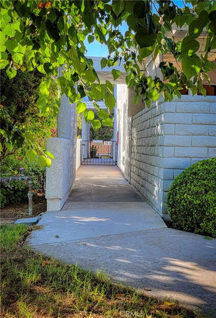 Front view of a house entrance with a walkway leading to a gated entry.