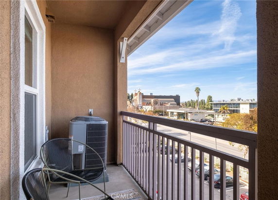Balcony view overlooking a cityscape with buildings and a clear sky.