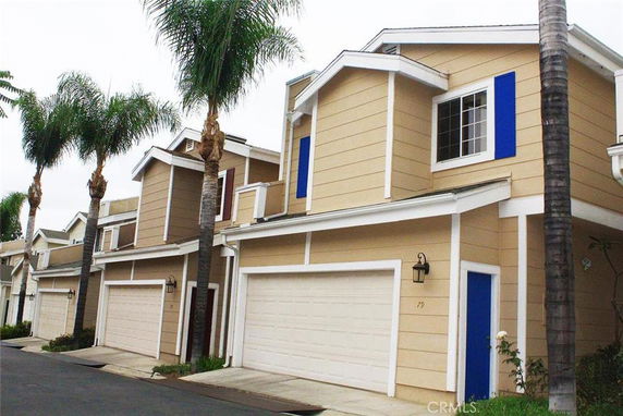 Front view of a row of attached modern townhouses with garages.