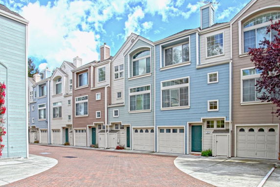 Front view of multi-story townhouses with garages beneath.