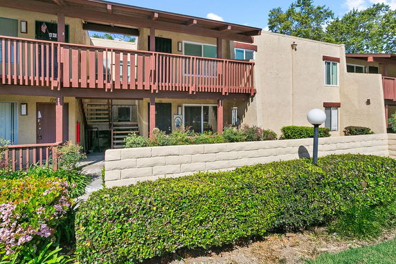 Front view of a two-story apartment building with exterior staircases and balconies.