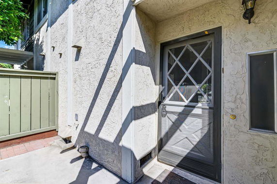 Front view of a house with a screen door and textured wall.