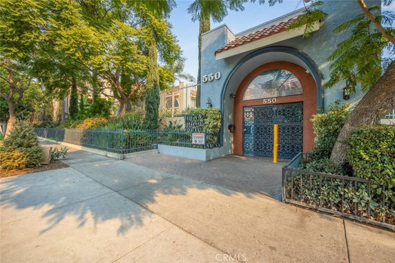 Front view of a building with an arched entrance and decorative gate.