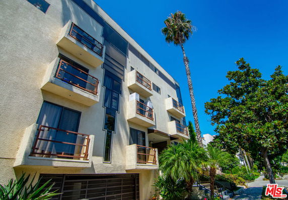 Front view of a multi-story apartment building with balconies.