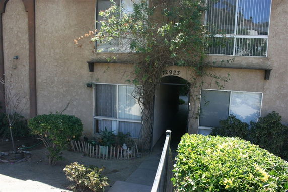 Front view of a two-story building with a pathway leading to the entrance.