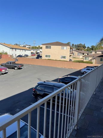 Outdoor parking area with several parked cars adjacent to residential buildings.