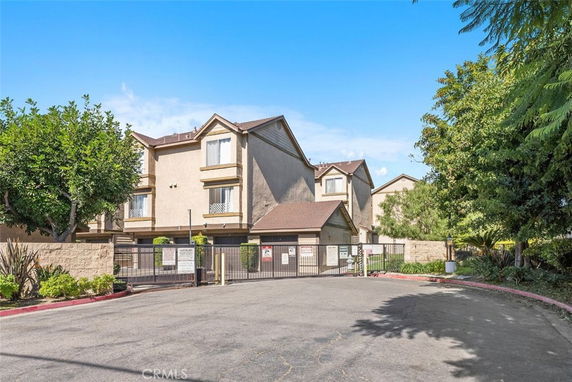 Front view of a multi-story residential building with gated entrance.