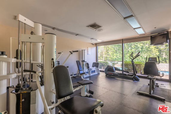 Indoor gym area with exercise equipment and large windows.