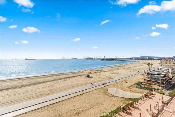 Panoramic view of a beach and ocean with a boardwalk.