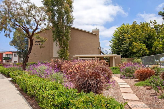 Front view of a multi-story residential building with a pathway and landscaping.