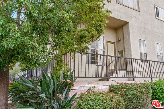 Front view of a building with a metal railing and entrance stairs.