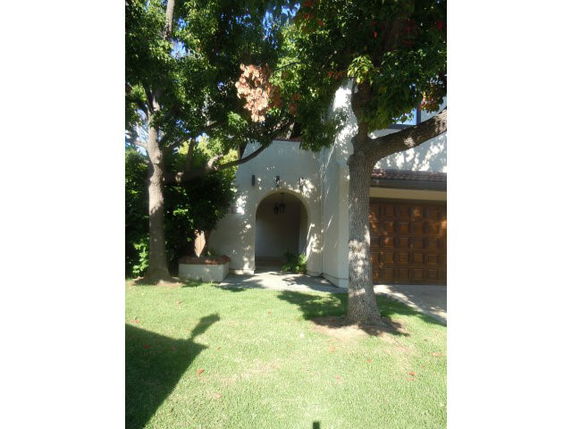 Front view of a house with an arched entryway and garage.