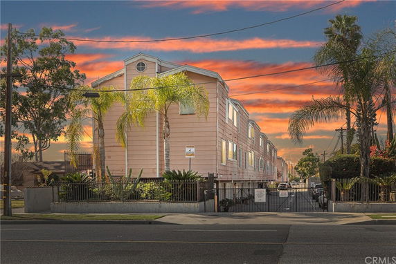 Front view of a multi-story residential building with a gated entrance.
