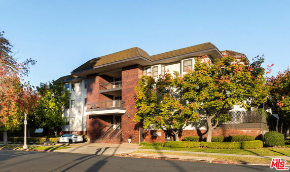 Front view of a multi-story residential building with brick and white exterior.