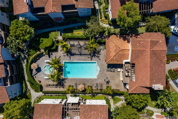 Aerial view of a swimming pool area surrounded by buildings and landscaping.