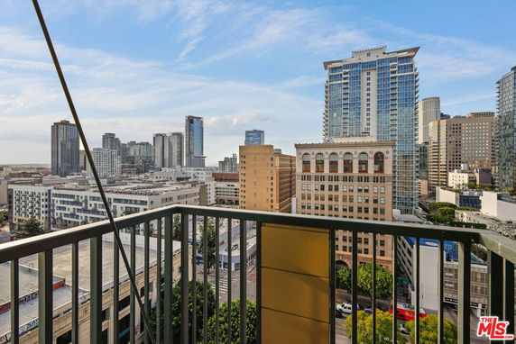 Panoramic view of a cityscape from a balcony, showcasing tall buildings and skyscrapers.