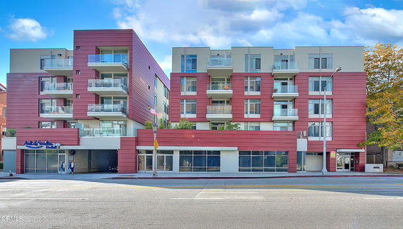Front view of a modern multi-story apartment building with balconies.