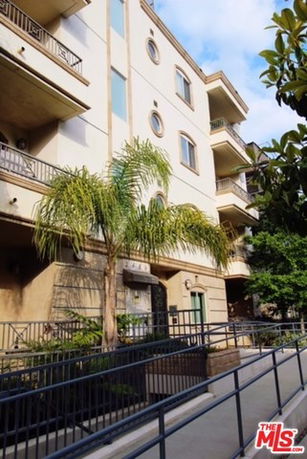 Front view of a multi-story building with balconies and circular windows.