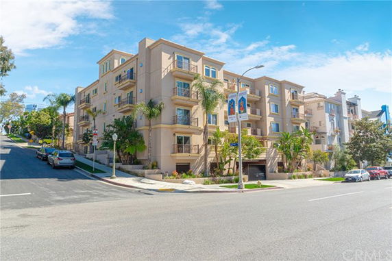 Front view of a multi-story apartment building on a street corner.