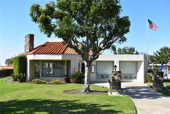 Front view of a single-story building with a tiled roof and a chimney.