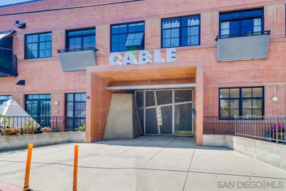 Front view of a brick building with large windows and an entrance marked 'CABLE'.
