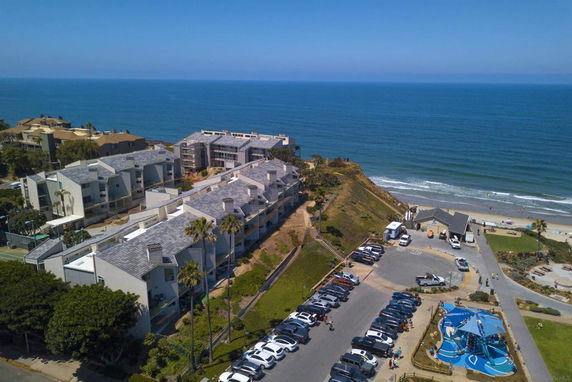 Aerial view of a coastal residential area with buildings near the ocean.