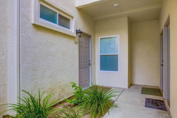 Front view of a house entrance with a door and windows.