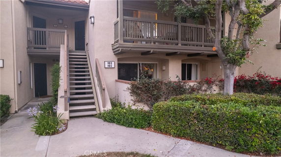Front view of a two-story residential building with exterior stairs and balconies.