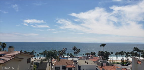 Wide-angle view of buildings near the coastline with ocean and sky in the background.