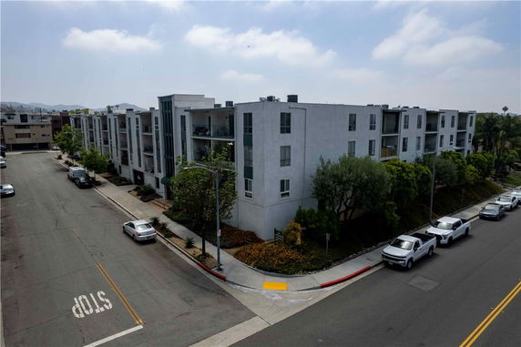 Front view of a multi-story apartment building on a street corner.