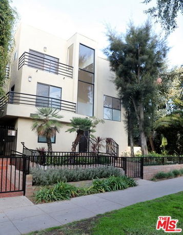 Front view of a modern multi-story building with large windows and balconies.