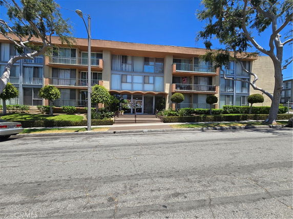 Front view of a multi-story apartment building with balconies.