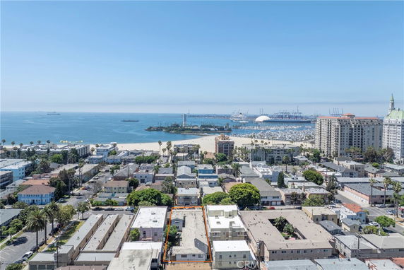 Panoramic view of a coastal city with buildings and the ocean in the background.
