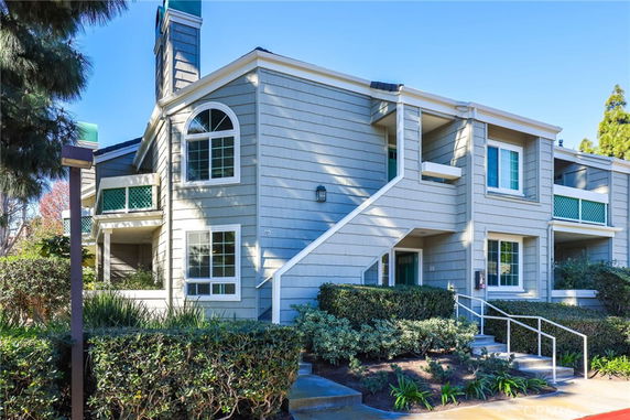 Front view of a multi-story residential building with external stairs.