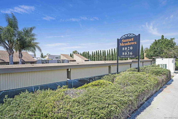 Elevated view of Sunset Meadows with a building and a sign indicating the address.