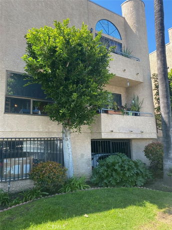 Front view of a multi-story building with balconies and windows.