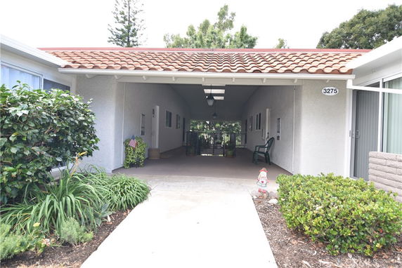 Front view of a house with a covered driveway and a red-tiled roof.